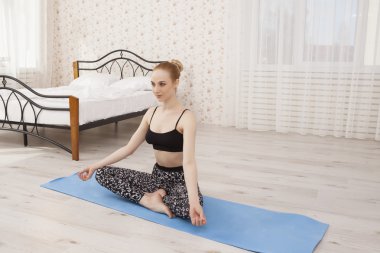 Güzel genç kadın Yoga ana sayfa - meditasyon yatak yakınındaki pratik