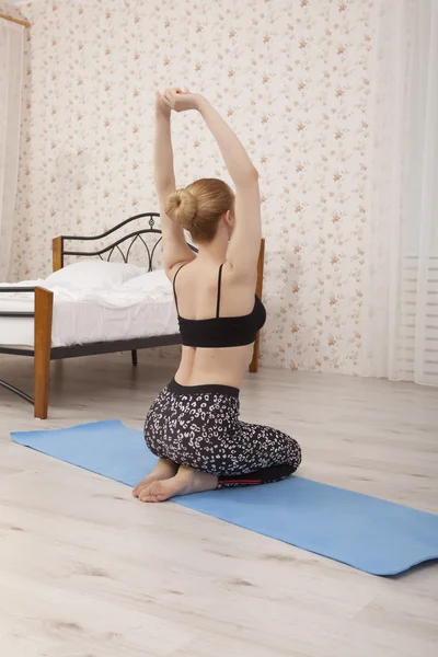 Schöne junge Frau praktiziert Yoga Stretching zu Hause auf Matte — Stockfoto