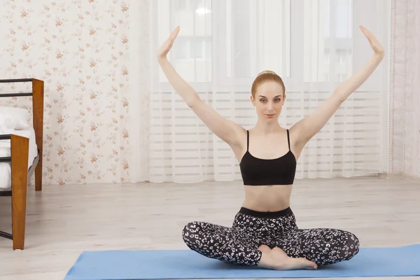 Hermosa joven practicando yoga en casa sobre alfombra - meditación — Foto de Stock