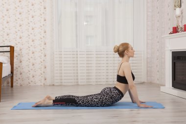 Güzel ve genç birbayan pratik yoga mat - Kobra poz evde germe