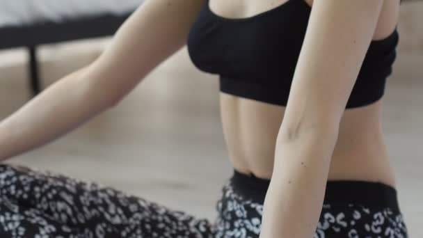 Красивая молодая женщина практикует йогу дома на синем коврике — стоковое видео