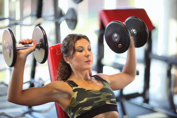 Hermosa mujer atlética sacude sus músculos abdominales. Fitness chica gimnasio —  Fotos de Stock