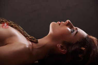 Boynundaki turuncu python ile seksi esmer kız