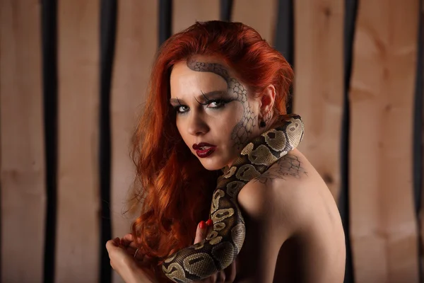 Nude portrait of lovely young woman with orange python — Stock Photo, Image