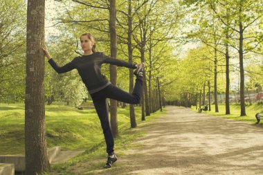 Açık havada çalıştırmadan önce ısınma ve germe mutlu genç kadın. Koşucu kız