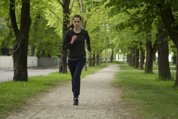 Runner in action. Jogging woman running in park on beautiful — Stock Photo, Image