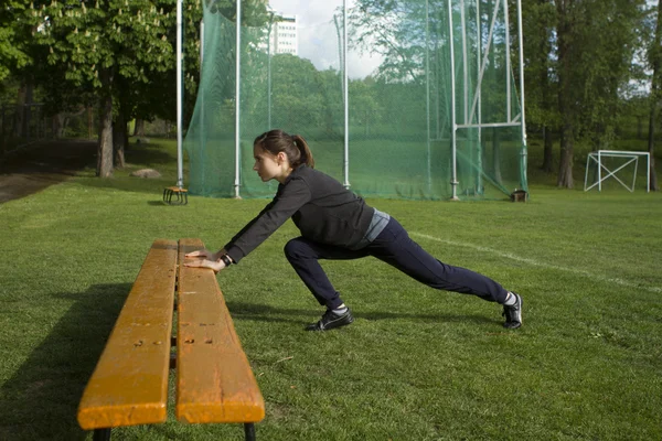 Giovane donna felice che si estende e si riscalda prima di treno all'aperto sullo stadio. Runner ragazza, campo sportivo — Foto Stock