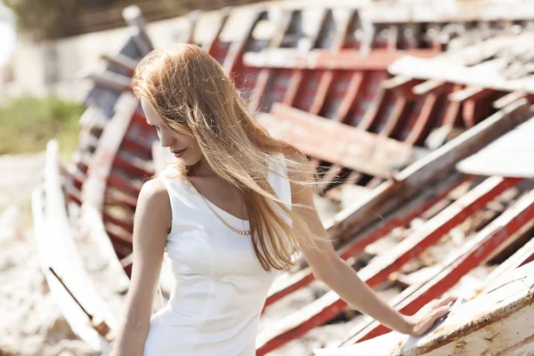 Belle jeune mariée assise sur un bateau près de la mer — Photo