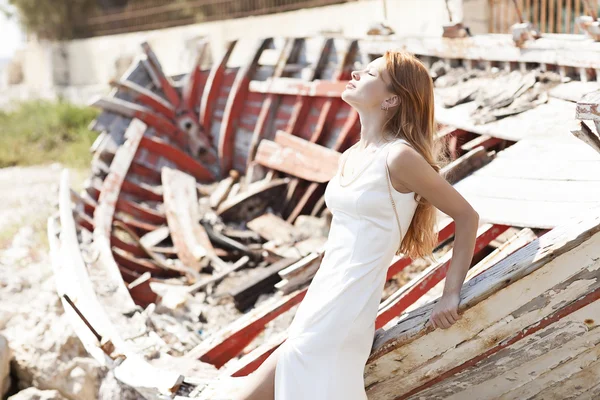 Bella giovane sposa seduta su una barca vicino al mare — Foto Stock