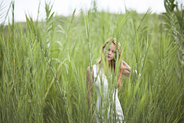 Beautiful angelic bride outdoors with long grass
