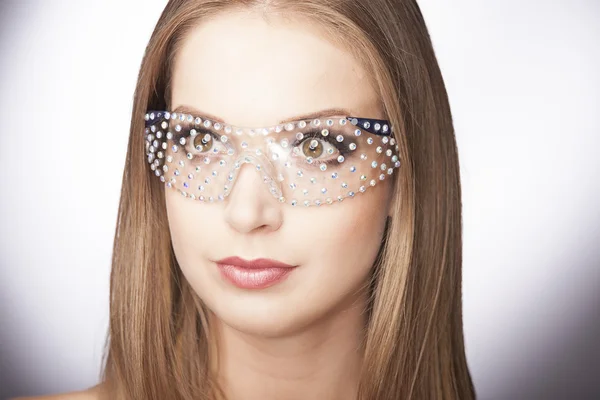 Close-up portrait of beautiful young woman in glasses on dark blue background — Stock Photo, Image