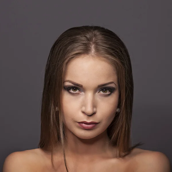 Retrato de cerca de una hermosa joven sobre fondo azul oscuro — Foto de Stock