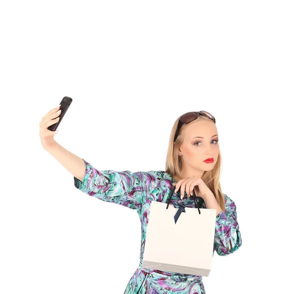 Mooi meisje shopping tassen te houden en het nemen van selfie met mobiele telefoon geïsoleerd — Stockfoto