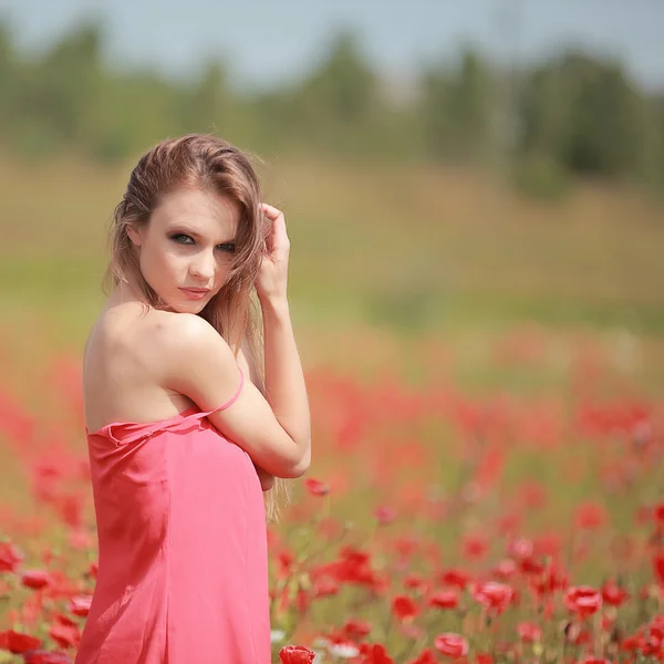 漂亮的女孩在罂粟的领域，红色礼服 — 图库照片