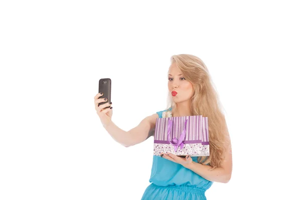 Menina bonita segurando sacos de compras e tomando selfie com telefone celular — Fotografia de Stock