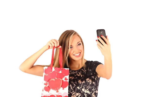 Mooi meisje shopping tassen te houden en het nemen van selfie met mobiele telefoon geïsoleerd — Stockfoto