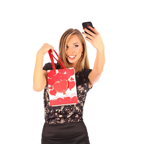 Krásná dívka drží nákupní tašky a s selfie s mobilní telefon, samostatný — Stock fotografie