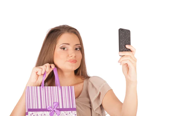 Bella ragazza tenendo borse della spesa e prendendo selfie con cellulare isolato — 图库照片
