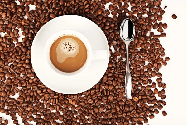 Šálek kávy a fazole na bílém pozadí. — Stock fotografie