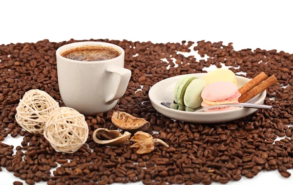 Šálek kávy s zákusek makarónek a fazole na bílém pozadí. — Stock fotografie