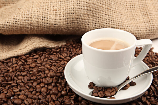 чашка кофе и бобы на белом фоне.