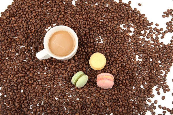 Xícara de café com macaroon e feijão em um fundo branco . — Fotografia de Stock