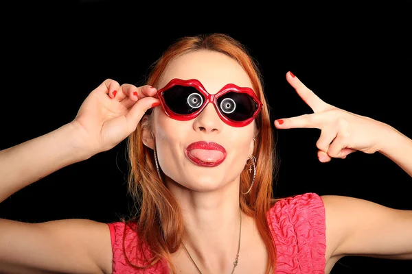 Menina com óculos em forma de coração e olhos fechados sorrindo — Fotografia de Stock