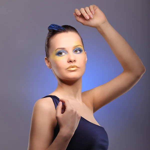 Όμορφη νεαρή γυναίκα με μπλε δημιουργική μακιγιάζ — Φωτογραφία Αρχείου