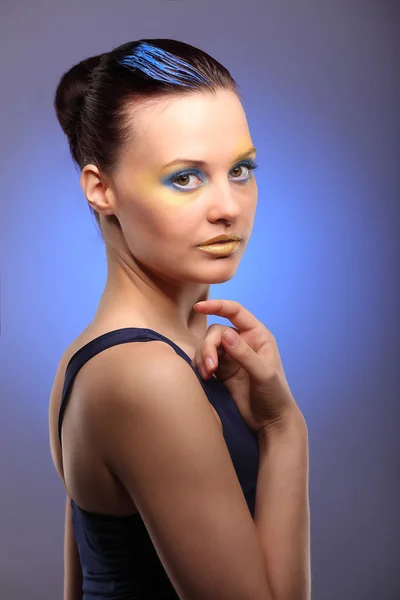 Красивая молодая женщина с синим креативным макияжем — стоковое фото