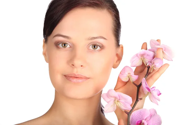 Bela cara de jovem morena com pele saudável e orquídea rosa — Fotografia de Stock