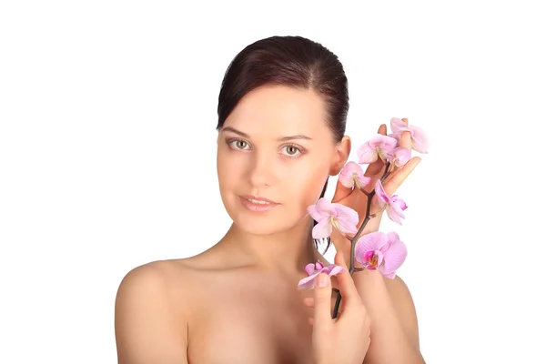 Bellissimo viso di giovane donna bruna con pelle sana e orchidea rosa — Foto Stock