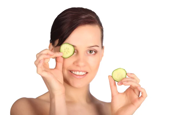 Mujer joven con rodajas de pepino en la cara en un spa —  Fotos de Stock