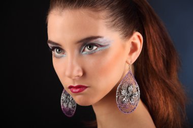 Karanlık bir arka plan üzerinde yaratıcı renkli makyaj ile güzel kız