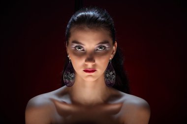 Karanlık bir arka plan üzerinde yaratıcı renkli makyaj ile güzel kız