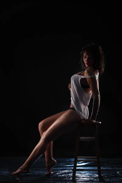 Mladá sexy nahá žena mokré, sedí na židli. Foto studio vody. — Stock fotografie