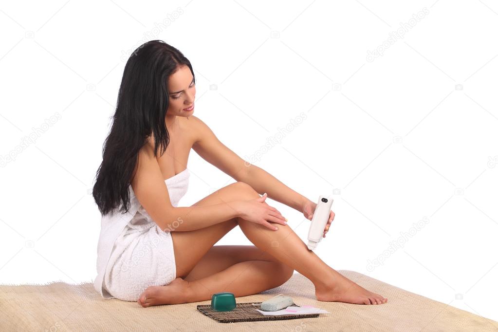 Beautiful female body legs with cosmetic container bowl and cream