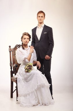 Portrait of young man and woman on vintage chair retro wedding