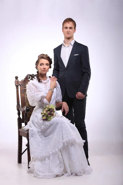 Portrait of young man and woman on vintage chair retro wedding — Stok fotoğraf