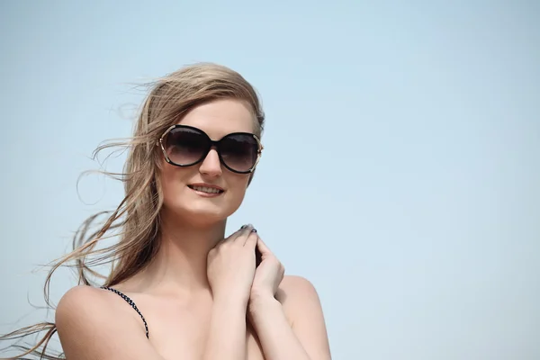 Mooie jonge vrouw in bikini op het zonnige strand — Stockfoto
