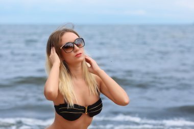 Güneşli sahilde bikinili güzel genç kadın