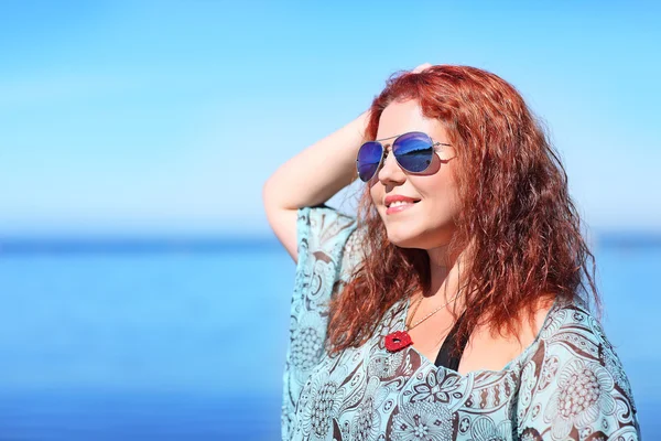 Kızıl saçlı artı boyutu kadın kıyısında dinlenme — Stok fotoğraf