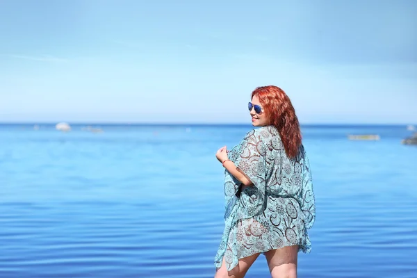 Vermelho-haired plus tamanho mulher descansando na costa — Fotografia de Stock