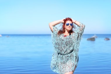 Red-haired plus size woman resting on coast