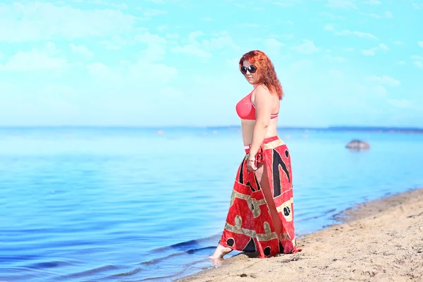 Vermelho-haired plus tamanho mulher descansando na costa — Fotografia de Stock