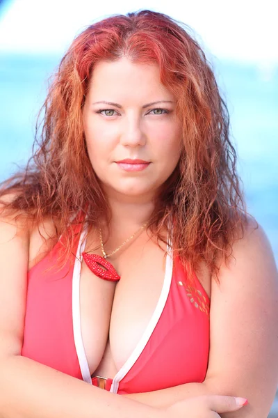 समुद्र तट पर आराम करने वाले धूप के चश्मे में लाल बालों वाली महिला — स्टॉक फ़ोटो, इमेज