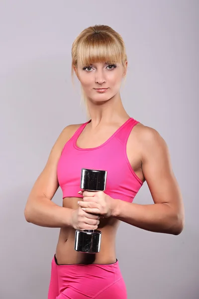 Fitness meisje met halters op een donkere achtergrond — Stockfoto