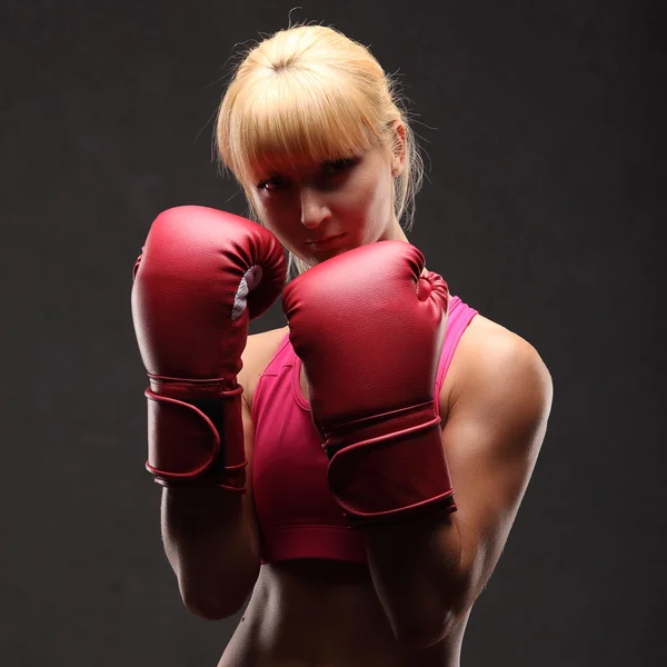 Joven chica sexy sobre fondo negro con guantes de boxeo — Foto de Stock