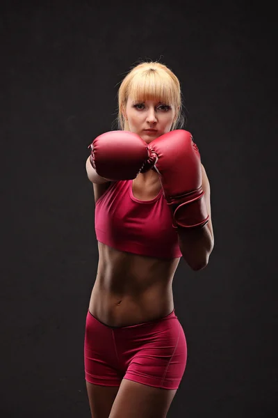 Junges sexy Mädchen auf schwarzem Hintergrund mit Boxhandschuhen — Stockfoto
