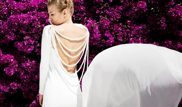 Elegante chica en vestido blanco sobre flores . — Foto de Stock