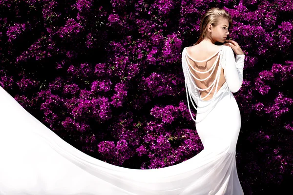 Menina elegante em vestido branco sobre flores . — Fotografia de Stock